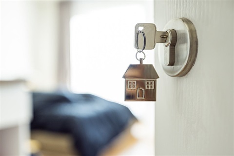 Photo of key in lock with door open of home